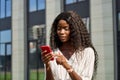 Young black business woman using mobile cell phone standing outdoors. Royalty Free Stock Photo