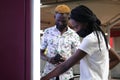 Young african passengers wearing protective face masks buying subway ticket at terminal Royalty Free Stock Photo