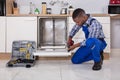 Repairman Fixing Dishwasher Royalty Free Stock Photo