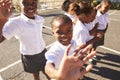 Young African schoolgirls in a playground waving to camera Royalty Free Stock Photo