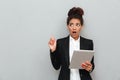 Young african shocked business woman over grey wall Royalty Free Stock Photo
