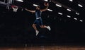 Young African sportsman, basketball player training in gym, idoors isolated on dark background. Concept of sport, game Royalty Free Stock Photo