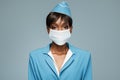 Young african stewardess wearing an antiviral mask on her face.