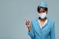 Young african stewardess wearing an antiviral mask on her face.