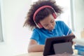 Young African students wearing headphones to study online using a tablet Royalty Free Stock Photo