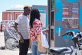 Young african tourists renting a bike at a bicycle rental service machine