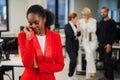 Young african woman crying because of the ridicule of colleagues. Racial discrimination in the office.