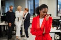 Young african woman crying because of the ridicule of colleagues. Racial discrimination in the office.