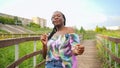 Young african woman dancing gait walking across the bridge