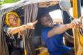 young african woman giving directions to the driver of an auto rickshaw taxi, pointing in the direction she wants to go Royalty Free Stock Photo