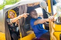 young african woman giving directions to the driver of an auto rickshaw taxi, pointing in the direction she wants to go Royalty Free Stock Photo