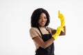 Young african woman hausewife cleaning with yellow gloves giving a thumbs-up isolated on white background. Happy cleaner having Royalty Free Stock Photo