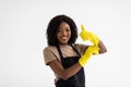 Young african woman hausewife cleaning with yellow gloves giving a thumbs-up isolated on white background. Happy cleaner having Royalty Free Stock Photo