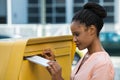 Woman Inserting Letter In Mailbox Royalty Free Stock Photo