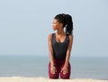 Young african woman kneeling outdoors on beach Royalty Free Stock Photo