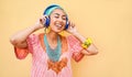 Young african woman listening music with headphones device - Happy girl having fun dancing and singing outdoor - Lifestyle, Royalty Free Stock Photo