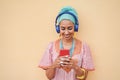 Young african woman listening music playlist while looking on mobile phone - Focus on face Royalty Free Stock Photo