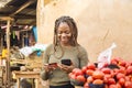 young african woman in a local african market using her mobile phone and credit card for a transaction Royalty Free Stock Photo