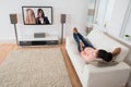 Woman Lying On Sofa Watching Television Royalty Free Stock Photo