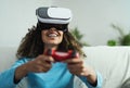 Young African woman playing online video games - Happy gamer having fun on new technology console with virtual reality experience