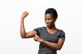 Young African woman pointing to her arm muscles