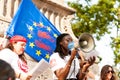 Barcelona, spain- 17 july 2019: young african woman reading manifesto against far right eith european union flag with blood