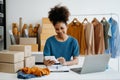 Young African woman running online store Startup small business SME, using smartphone or tablet taking receive and checking online Royalty Free Stock Photo