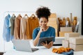 Young African woman running online store Startup small business SME, using smartphone or tablet taking receive and checking online Royalty Free Stock Photo