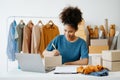 Young African woman running online store Startup small business SME, using smartphone or tablet taking receive and checking online Royalty Free Stock Photo