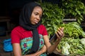 Young african woman selling in a local market feeling sad and dejected while looking at her phone