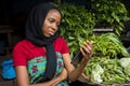 Young african woman selling in a local market feeling sad and dejected while looking at her phone Royalty Free Stock Photo