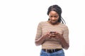 Young african woman sending a sms on her smartphone isolated on white background Royalty Free Stock Photo