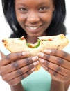 Young african woman showing her sandwich