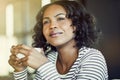 Smiling young African woman deep in thought while drinking coffe Royalty Free Stock Photo