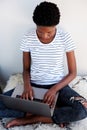 Young african woman sitting on floor and working laptop computer Royalty Free Stock Photo