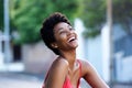 Young african woman sitting outdoors and laughing Royalty Free Stock Photo