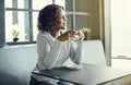 Young African woman smiling while drinking coffee in a cafe Royalty Free Stock Photo