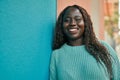 Young african woman smiling happy leaning on the wall Royalty Free Stock Photo