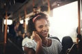 Smiling African woman standing on a bus listening to music Royalty Free Stock Photo