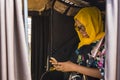 young african woman smiling while using her mobile phone, sitting in the back seat of an auto rickshaw taxi Royalty Free Stock Photo