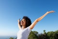 Young african woman standing outdoors with arms raised and laughing Royalty Free Stock Photo