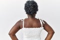 Young african woman standing over white isolated background standing backwards looking away with arms on body Royalty Free Stock Photo