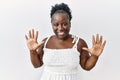 Young african woman standing over white isolated background showing and pointing up with fingers number ten while smiling Royalty Free Stock Photo