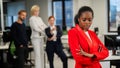 Young african woman is upset because of the ridicule of colleagues. Racial discrimination in the office.