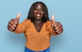 Young african woman wearing casual clothes approving doing positive gesture with hand, thumbs up smiling and happy for success Royalty Free Stock Photo