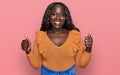 Young african woman wearing casual clothes success sign doing positive gesture with hand, thumbs up smiling and happy Royalty Free Stock Photo