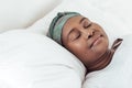 Young African woman wearing a headscarf asleep in bed Royalty Free Stock Photo