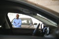 young africanamerican man came to see automobiles in dealership or cars showroom Royalty Free Stock Photo