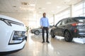 young africanamerican man came to see automobiles in dealership or cars showroom Royalty Free Stock Photo