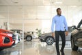 young africanamerican man came to see automobiles in dealership or cars showroom Royalty Free Stock Photo